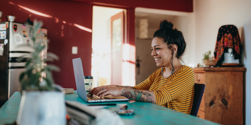 Woman smiling using a laptop.