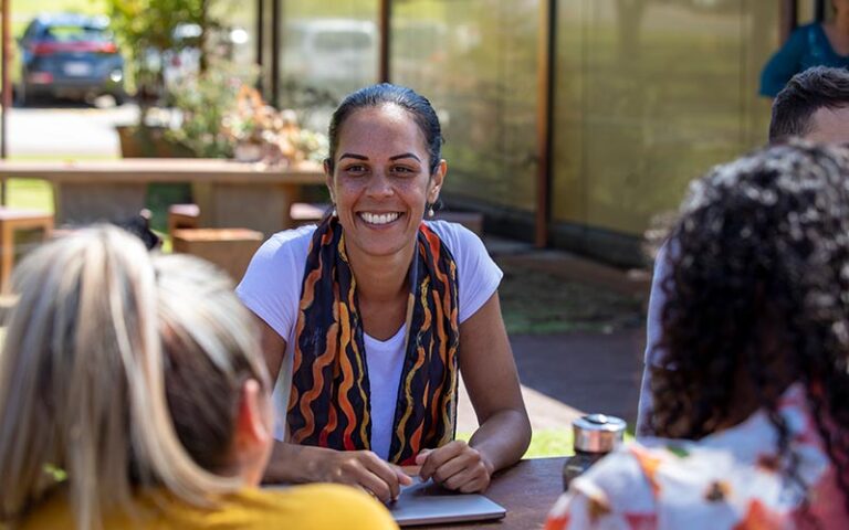Young indigenous woman smiling and helping others