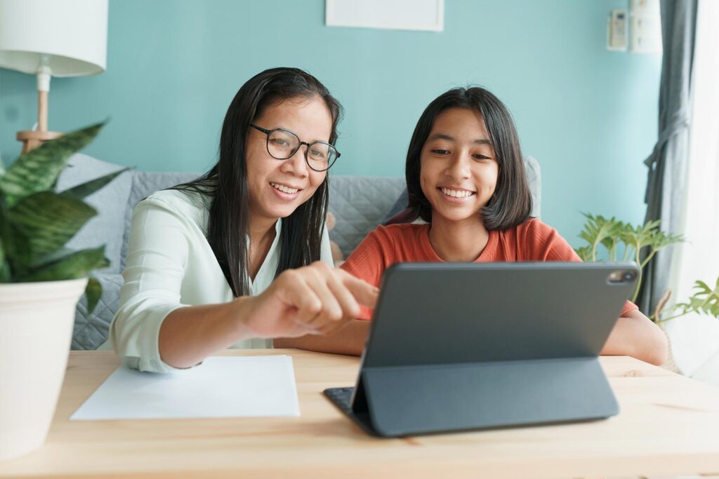 Girl doing homework with help from mum