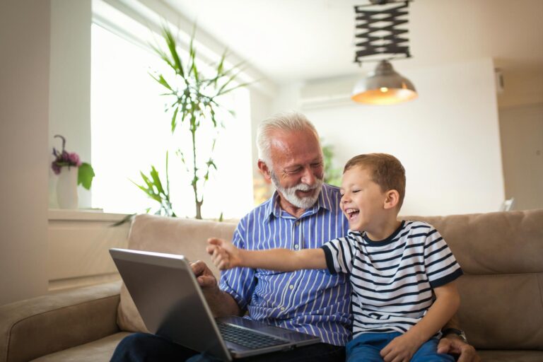 Young boy and his grandfather look at a tablet