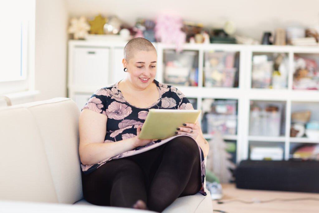 Beautiful young overweight woman using digital tablet at home