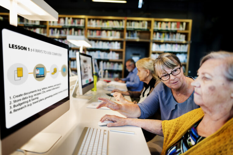 A digital skills lesson at a local library with 4 older people learning