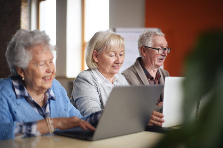 Senior group in retirement home learning together in computer class